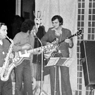 Black and white photo of a band performing indoors.