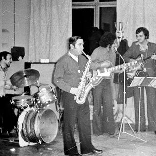 Black and white photo of a band performing indoors.