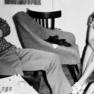 Black and white photo of three people in a room.