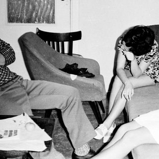 Black and white photo of three people in a room.