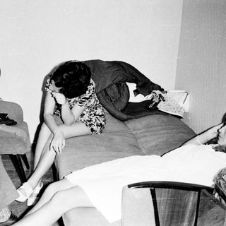 Black and white photo of three people in a room.