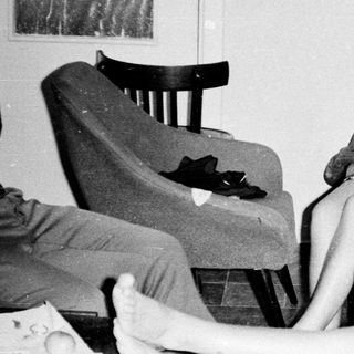 Here's a brief summary of the image: Two women appear distressed in a dimly lit room.