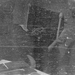 Black and white image with scratches and faded shapes.
