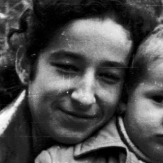 Woman and child standing outdoors in a black and white photo.