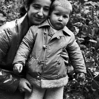 Woman and child standing outdoors in a black and white photo.