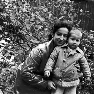 Woman and child standing outdoors in a black and white photo.