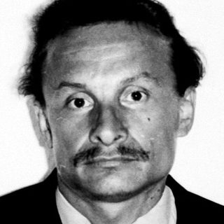 Black and white portrait of a man in a suit.