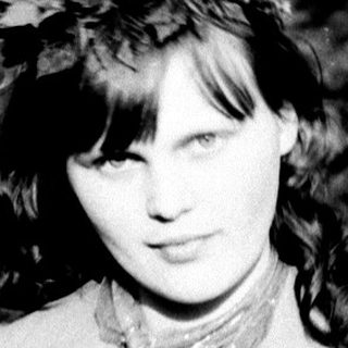 Black and white photo of a woman in a coat.