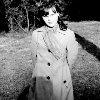 Black and white photo of a woman in a coat.