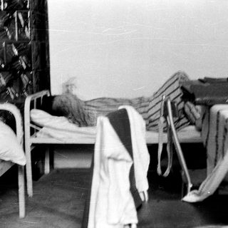 Here's a brief summary of the image: Beds in a room, possibly a hospital or dormitory.