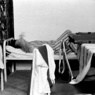 Here's a brief summary of the image: Beds in a room, possibly a hospital or dormitory.