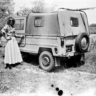 Black and white photo of a van and two people outdoors.
