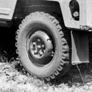 Black and white photo of a van and two people outdoors.