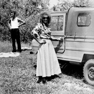 Black and white photo of a van and two people outdoors.