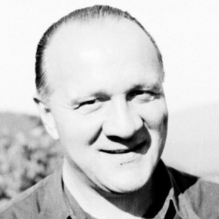 Black and white portrait of a man in a collared shirt.