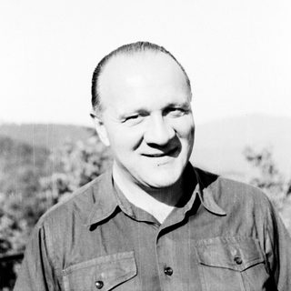 Black and white portrait of a man in a collared shirt.