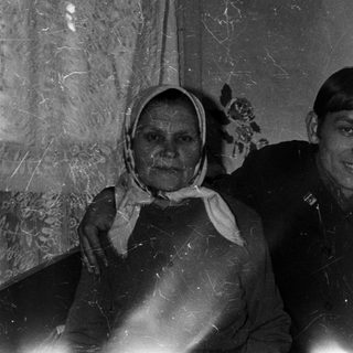 Here's a brief summary of the image: Three people posing indoors, likely a family portrait.