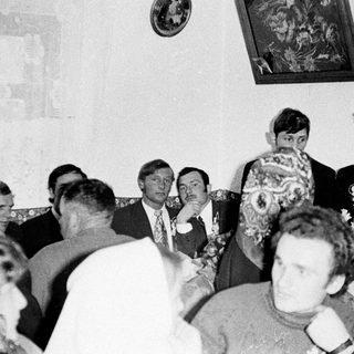 Group of formally dressed men and women in a room.