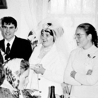 Black and white photo of a wedding reception gathering.