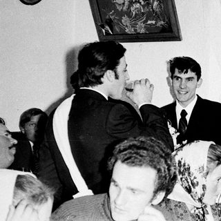Black and white photo of a wedding reception gathering.