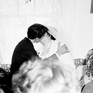 Couple embracing during what appears to be a wedding reception.
