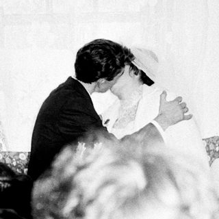 Couple embracing during what appears to be a wedding reception.