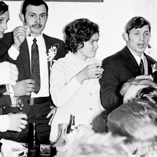 Group of men and a woman toasting with drinks.