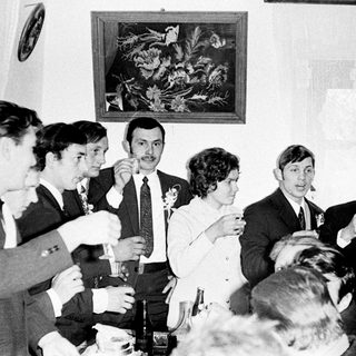 Group of men and a woman toasting with drinks.