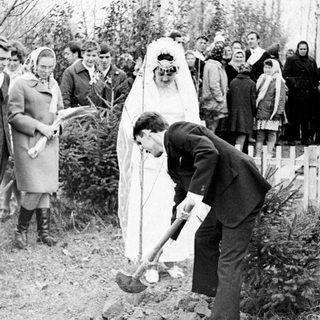 Bride and groom participate in a ceremony outdoors.