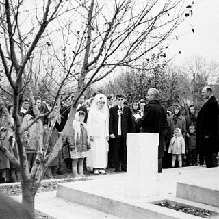 Group gathers for a ceremony near a monument.