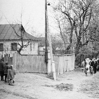 Group of people walking down a dirt road.