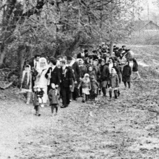 Group of people walking down a dirt road.