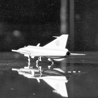 Model airplane rests on a reflective surface.