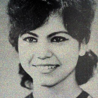 Black and white portrait of a smiling woman with short hair.