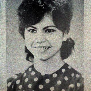 Black and white portrait of a smiling woman with short hair.
