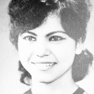 Black and white portrait of a smiling woman with dark hair.