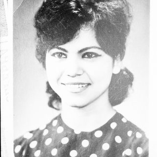Black and white portrait of a smiling woman with dark hair.