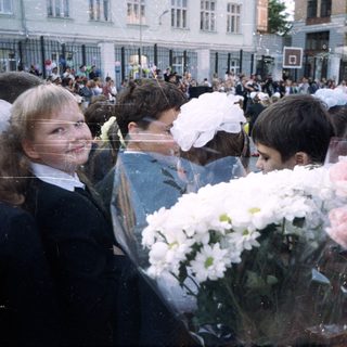 Group of children in formal wear with flowers outside.