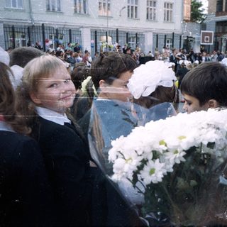 Group of children in formal wear with flowers outside.