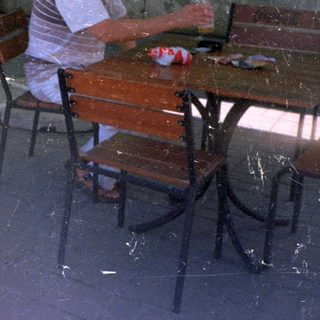 Man and child seated at a table outdoors.