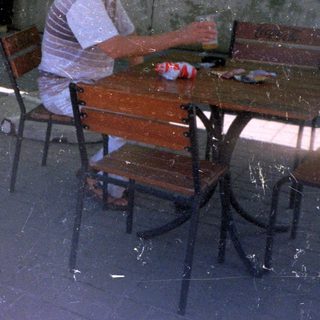 Man and child seated at a table outdoors.