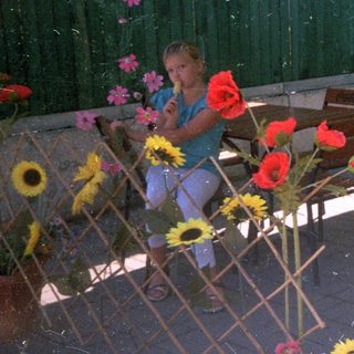 Man and child seated at a table outdoors.