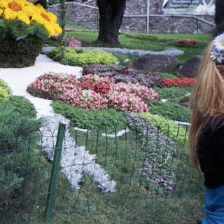 Floral display of a dove with a woman nearby.