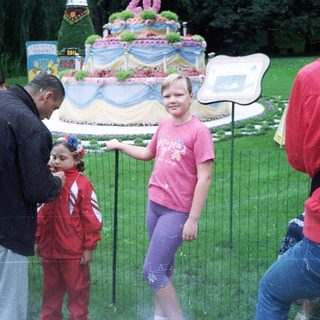 People view a large floral display with a young girl.