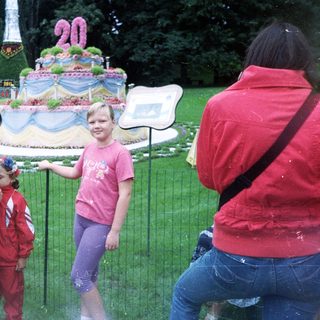 People view a large floral display with a young girl.