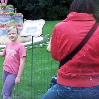 People view a large floral display with a young girl.