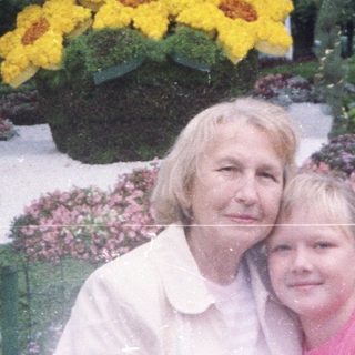 Woman and child near a flower display in a garden.