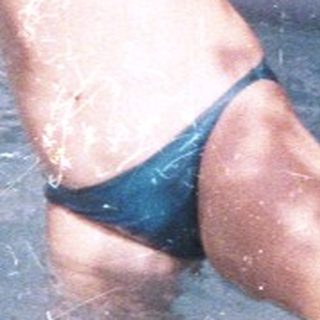 Boy joyfully swims in an inflatable pool with an adult.