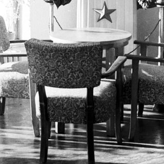 Here's a brief summary of the image: Bust of Lenin displayed with flags and furniture.