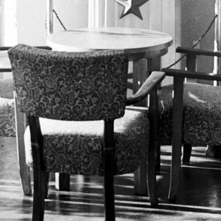 Here's a brief summary of the image: Bust of Lenin displayed with flags and furniture.